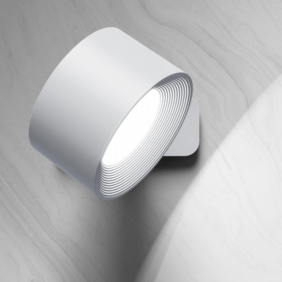 FlexiLamp lampada da parete ricaricabile con rotazione a 360 gradi: versione bianca accesa vista dall'alto su parete grigia - Luximode