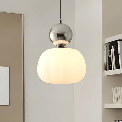 BauGlow con sfera argento accesa accanto a una libreria