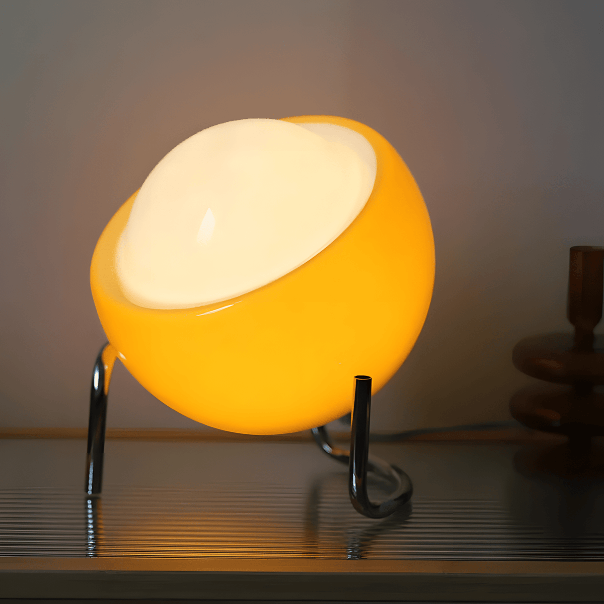 Bauhaus lampada da tavolo in vetro arancione e metallo cromato: primo piano della lampada accesa con il diffusore in vetro arancione - Luximode