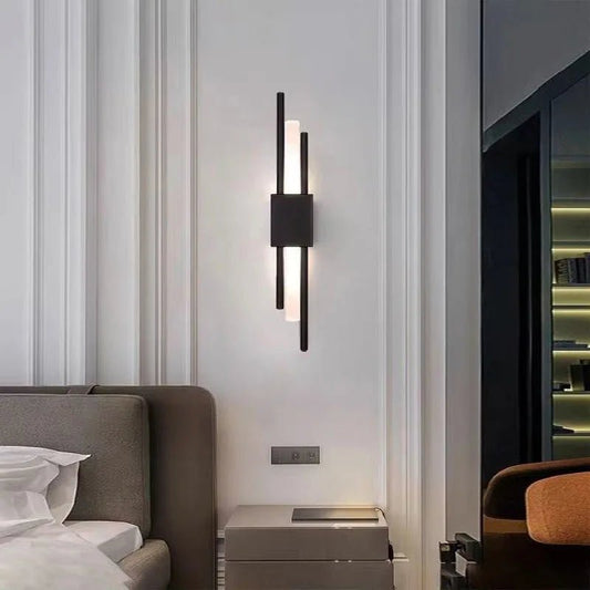 Applique BlackLara accesa accanto al letto in una camera moderna