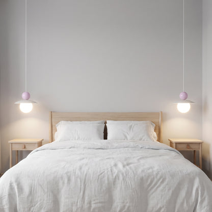 Due lampade Burano con sfera lilla ai lati del letto