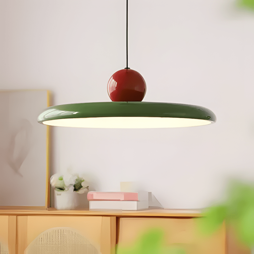 CeraVolta verde con sfera rossa accesa sopra una credenza in legno