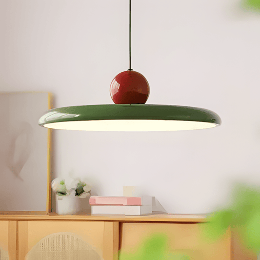 CeraVolta verde con sfera rossa accesa sopra una credenza in legno