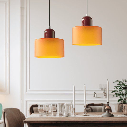 Due lampade Croma arancioni accese sopra un tavolo da pranzo