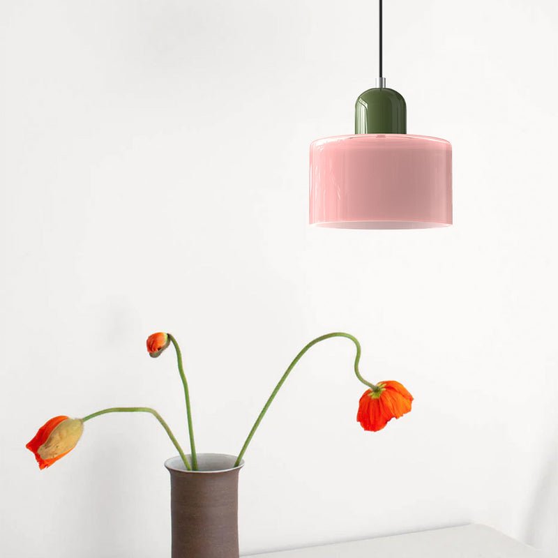 Croma rosa con calotta verde accanto a un vaso con papaveri