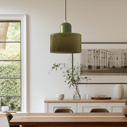Croma in vetro verde militare accesa sopra un tavolo da pranzo in una sala luminosa