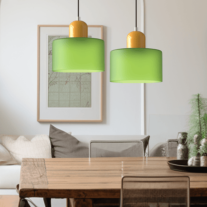 Due lampade Croma in vetro verde opaco con base gialla sopra un tavolo da pranzo in legno