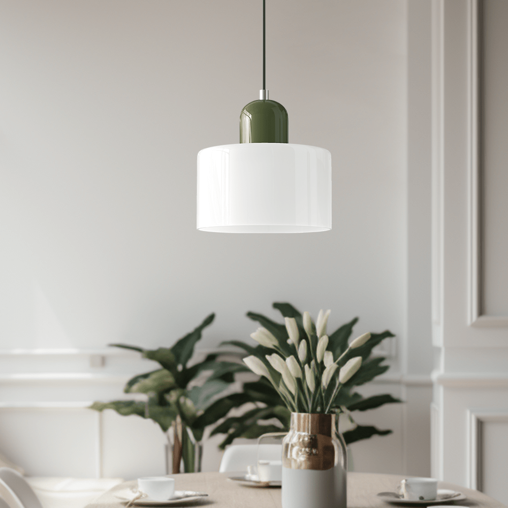 Croma in vetro bianco con base verde accesa sopra un tavolo da pranzo con pianta