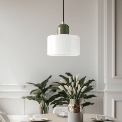 Croma in vetro bianco con base verde accesa sopra un tavolo da pranzo con pianta