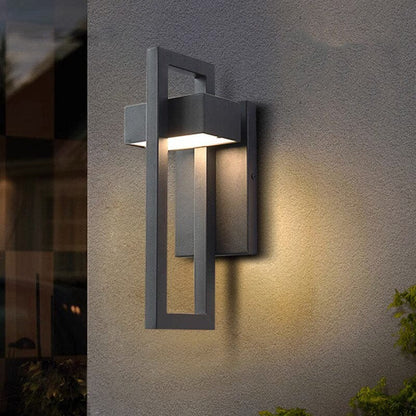 DuskGlow applique da esterno a parete LED in alluminio nero, design rettangolare: accesa su una parete beige di notte - Luximode