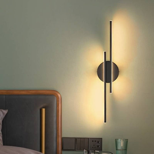 EclipseLine applique da parete moderna a barra LED lineare: applique nera verticale accesa accanto alla testiera in una camera da letto verde salvia - Luximode