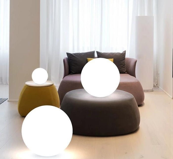 ElementLamp lampada portatile a sfera ricaricabile per interni ed esterni: due sfere accese in un soggiorno accanto a una poltrona - Luximode