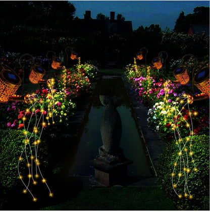 EnchantedCan lampada solare da esterno a forma di annaffiatoio con cascata di micro LED: tre annaffiatoi accesi lungo un vialetto di giardino - Luximode