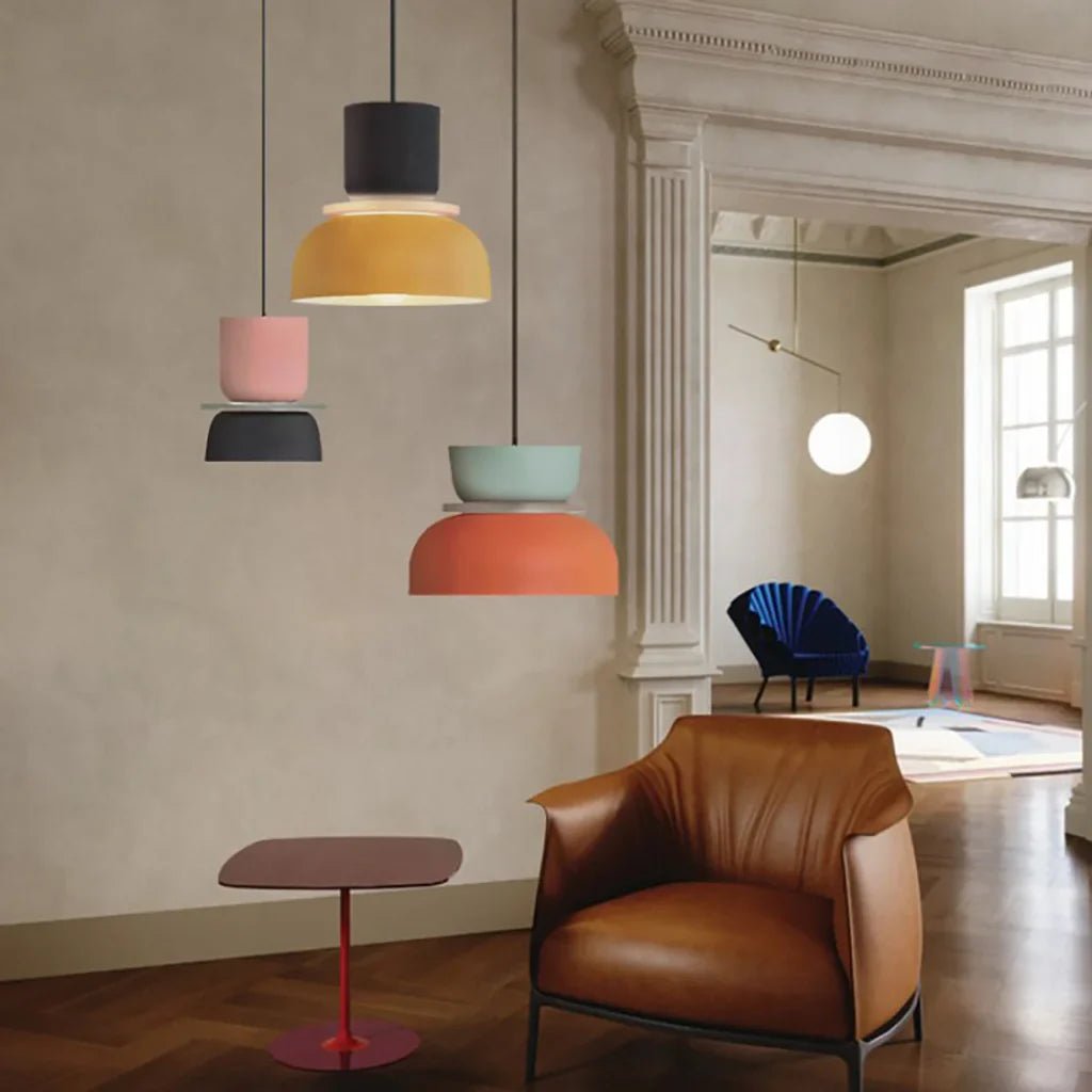 LucieBlock lampada a sospensione nordica in alluminio e acrilico: tre sospensioni colorate in un salotto con poltrona in pelle cognac - Luximode