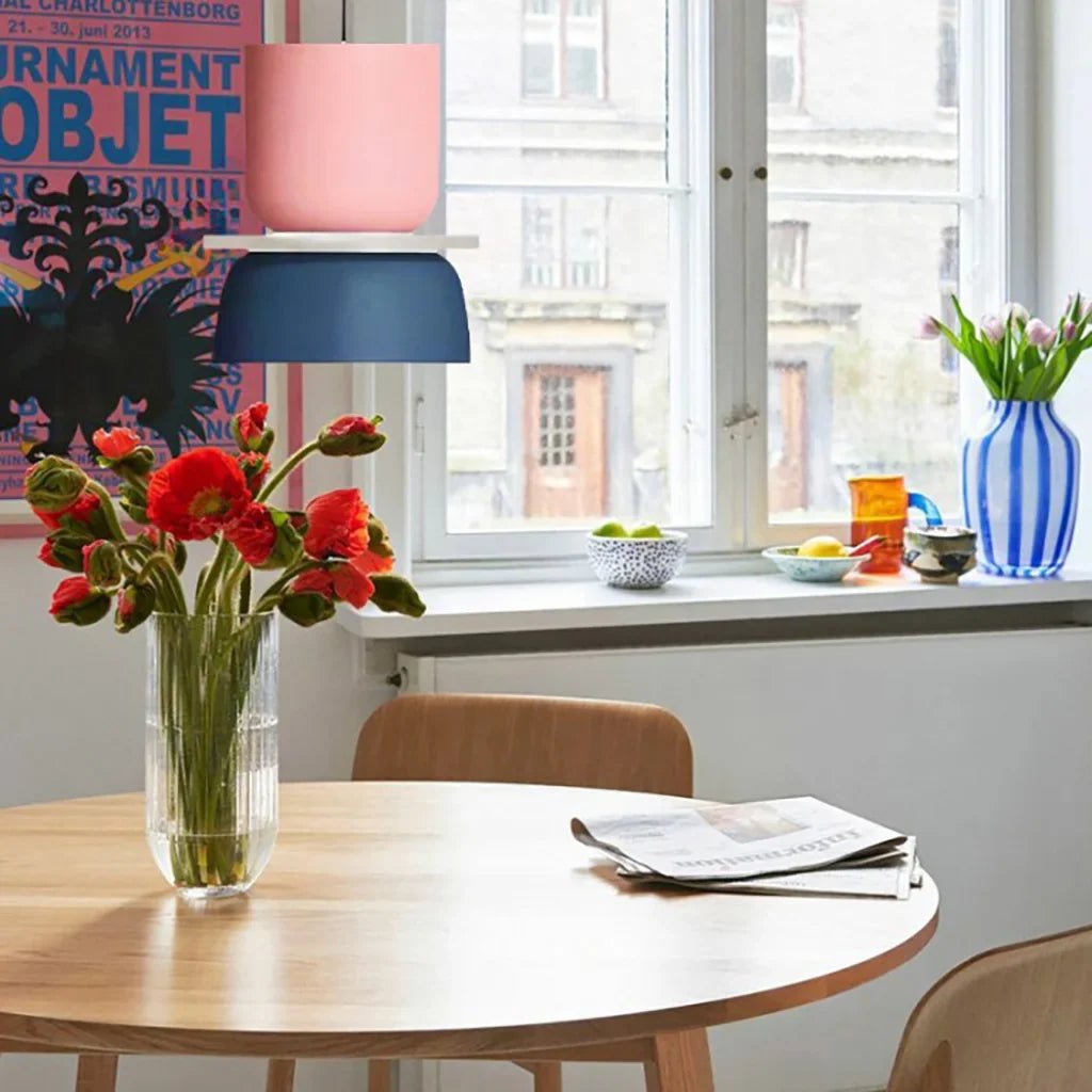 LucieBlock lampada a sospensione nordica in alluminio e acrilico: sospensione blu e rosa sopra un tavolo con fiori vicino alla finestra - Luximode