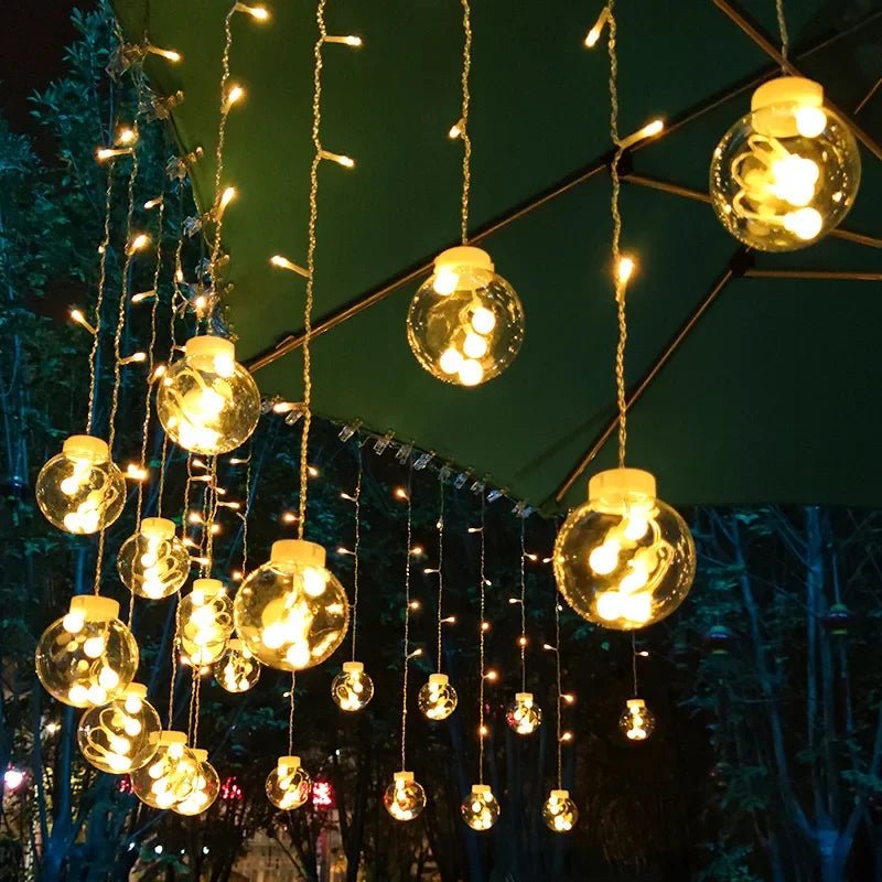 LumiFae catena luminosa LED impermeabile da esterno con sfere pendenti: primo piano delle sfere pendenti accese su un ramo - Luximode