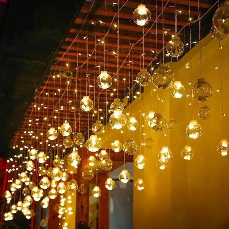 LumiFae catena luminosa LED impermeabile da esterno con sfere pendenti: catena accesa lungo una pergola con luce calda diffusa - Luximode