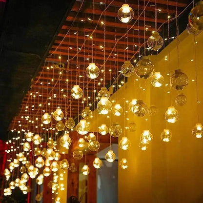 LumiFae catena luminosa LED impermeabile da esterno con sfere pendenti: catena accesa lungo una pergola con luce calda diffusa - Luximode
