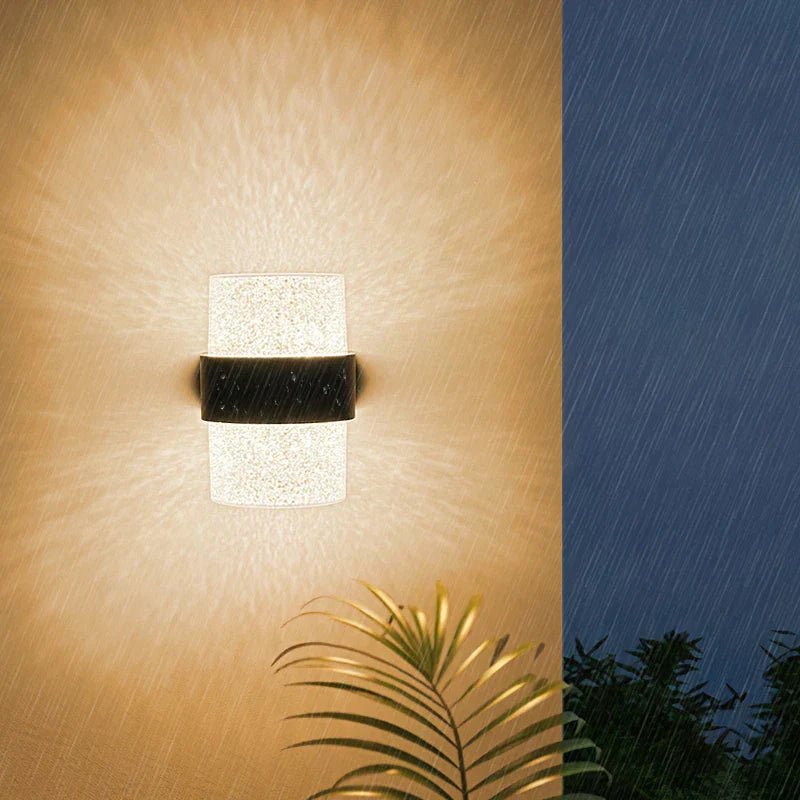 NatureBeam applique da esterno a parete moderna in alluminio nero e diffusore effetto pietra: lampada accesa di notte su parete esterna accanto a una palma - Luximode