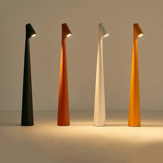 NordicSilhouette lampada da tavolo scandinava ricaricabile dalla forma conica: quattro lampade accese in colori diversi su un tavolo - Luximode