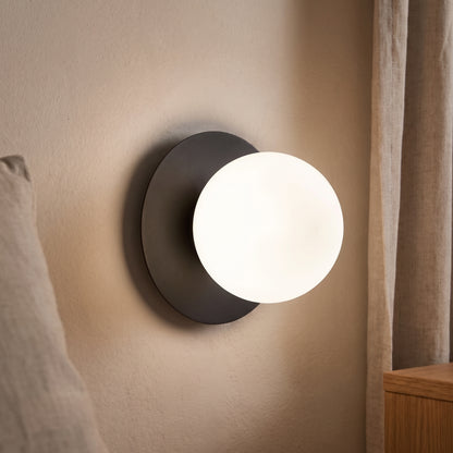 Ostuni nera accesa a parete, luce bianco neutro