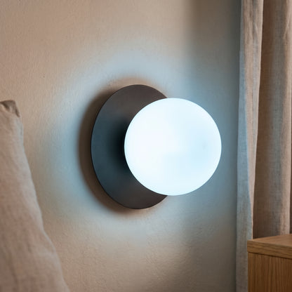 Ostuni nera accesa a parete, luce bianco freddo