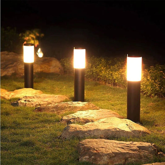 SolarGlow lampada solare da giardino impermeabile in acciaio: tre lampade accese lungo un vialetto di pietra in giardino di notte - Luximode
