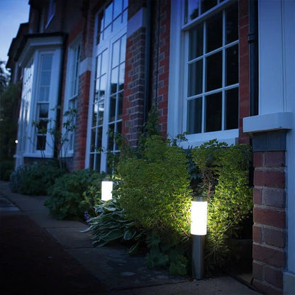 SolarGlow lampada solare da giardino impermeabile in acciaio: lampade accese davanti all'ingresso di una casa la sera - Luximode