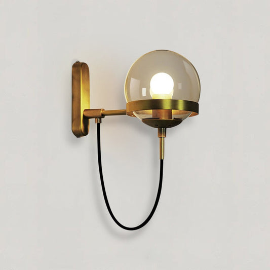 Applique Sphere oro con globo in vetro ambrato su parete chiara