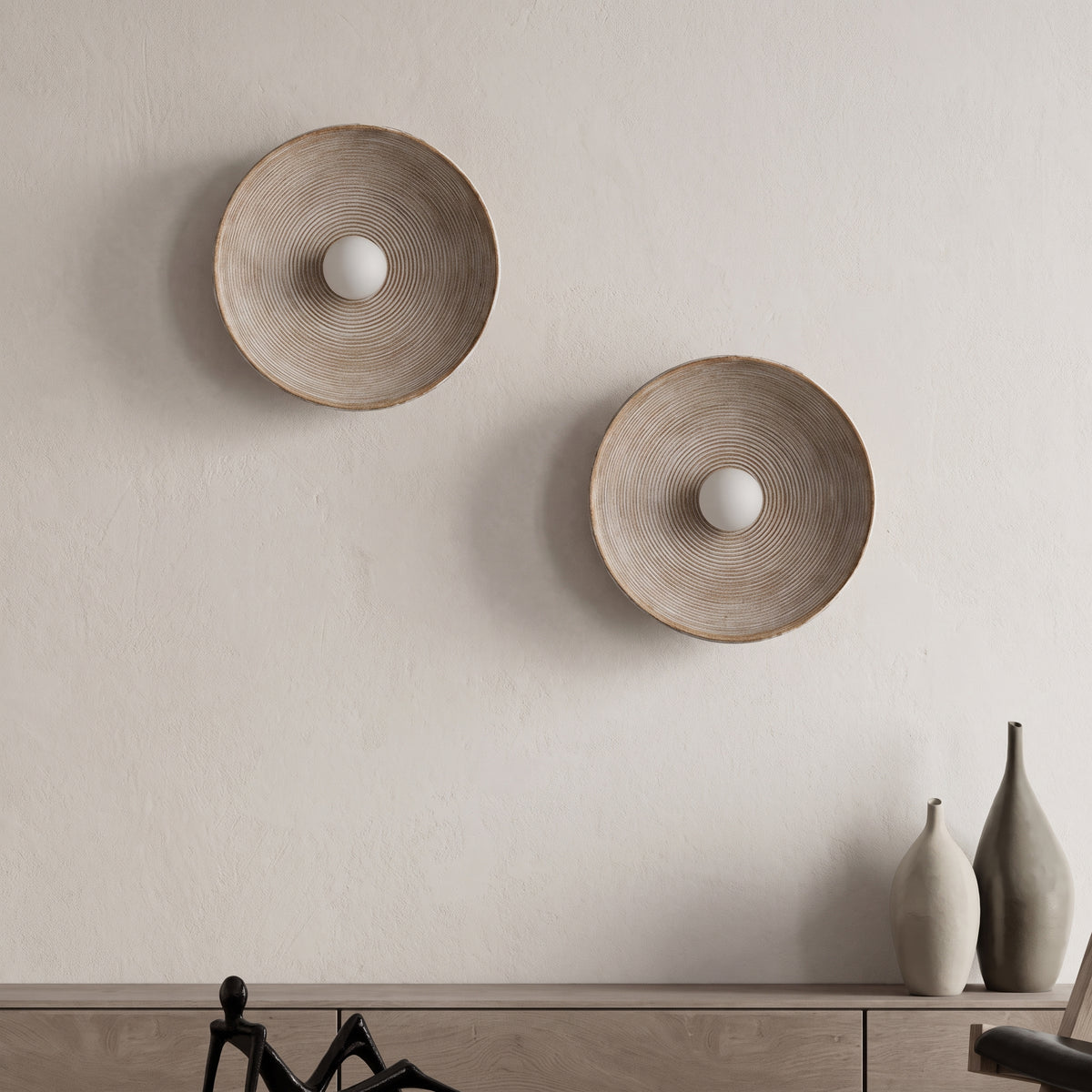 Coppia di applique Volterra su una parete beige sopra la credenza